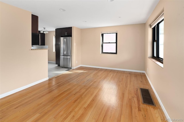 unfurnished room featuring visible vents, baseboards, and light wood-style flooring