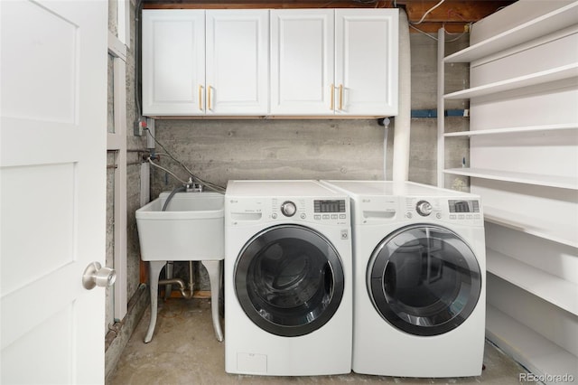 washroom featuring cabinet space and washer and clothes dryer