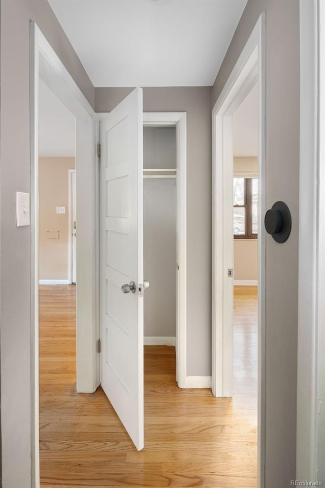 hallway with baseboards and light wood-style floors