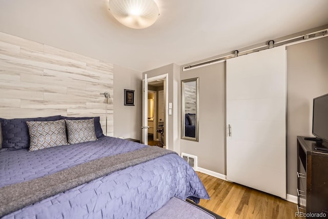 424 S Leyden St, Denver, CO 80224 - bedroom with wood finished floors, baseboards, and a barn door