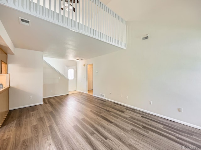 13598 E Asbury Dr, Aurora, CO 80014 - unfurnished living room with wood finished floors, baseboards, and a high ceiling