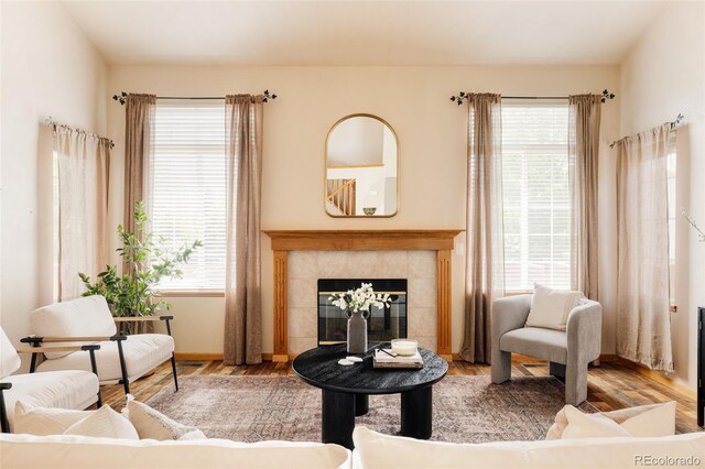 1157 Belleview Dr, Fort Collins, CO 80526 - living area featuring healthy amount of natural light, a tile fireplace, wood finished floors, and baseboards