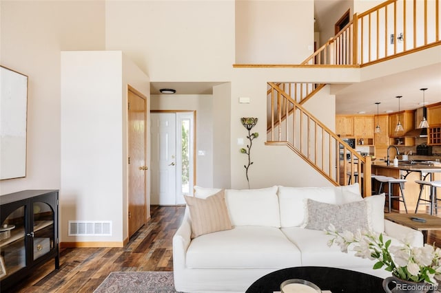 1157 Belleview Dr, Fort Collins, CO 80526 - living area with dark wood-style flooring, a towering ceiling, stairs, and baseboards