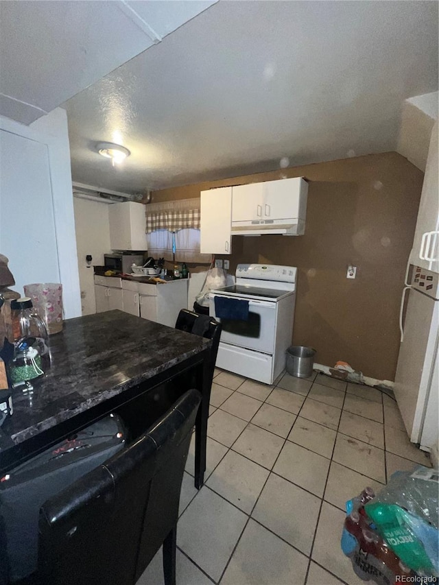 kitchen featuring light tile patterned flooring, a textured ceiling, electric range, and white cabinets
