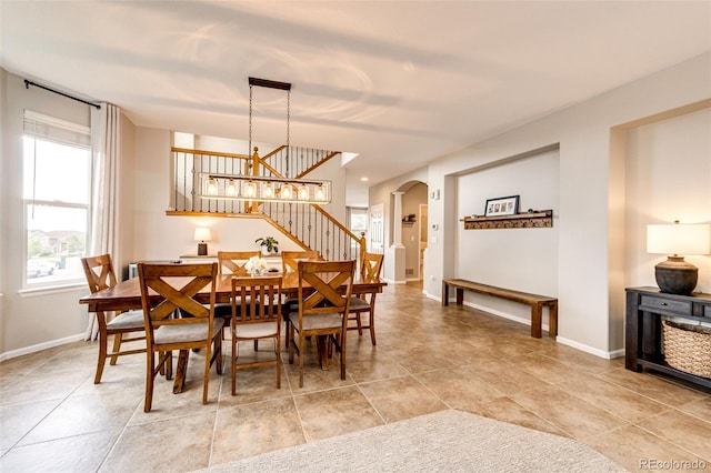 5550 Fox Meadow Ave, Highlands Ranch, CO 80130 - dining area with stairway, baseboards, arched walkways, and light tile patterned flooring