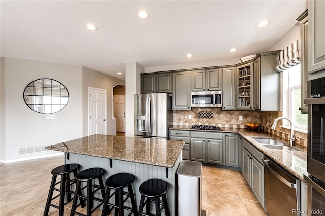 5550 Fox Meadow Ave, Highlands Ranch, CO 80130 - kitchen with appliances with stainless steel finishes, gray cabinets, a sink, recessed lighting, and tasteful backsplash