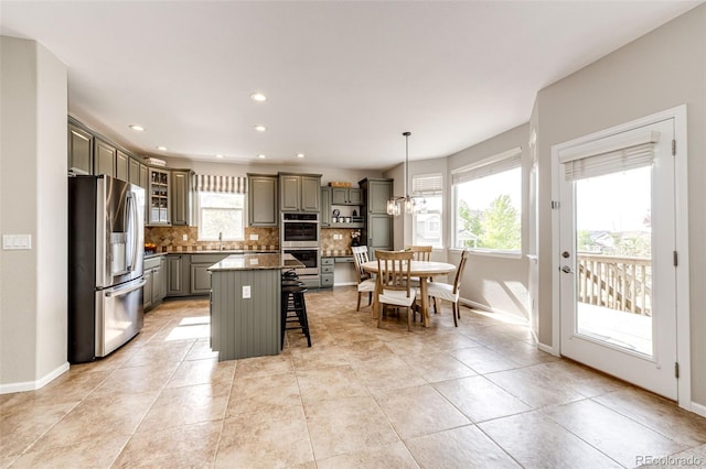 5550 Fox Meadow Ave, Highlands Ranch, CO 80130 - kitchen with appliances with stainless steel finishes, gray cabinetry, a breakfast bar, decorative backsplash, and a sink