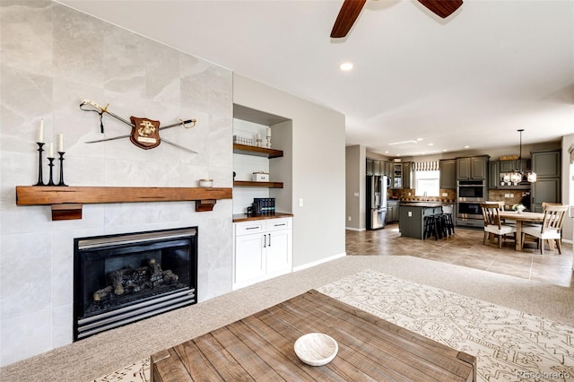 5550 Fox Meadow Ave, Highlands Ranch, CO 80130 - living area featuring a fireplace, recessed lighting, ceiling fan, baseboards, and light carpet