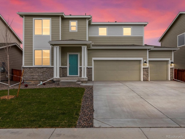 view of front facade with driveway, stone siding, and an attached garage