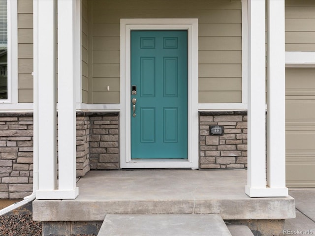 property entrance featuring covered porch and stone siding