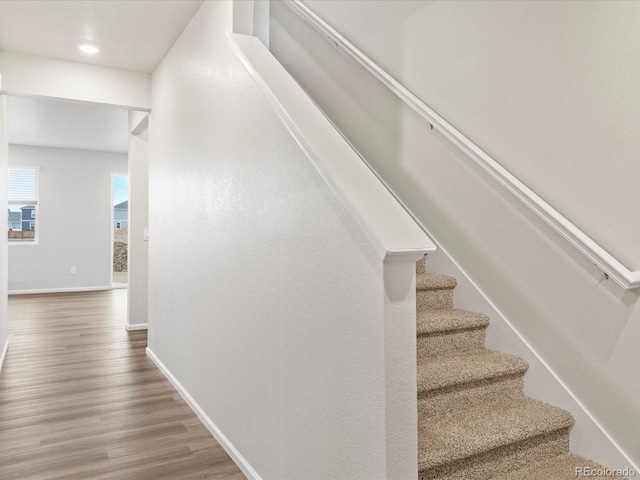 stairs with wood finished floors and baseboards