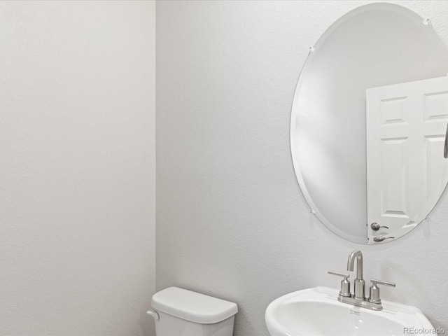 half bath featuring a sink and toilet