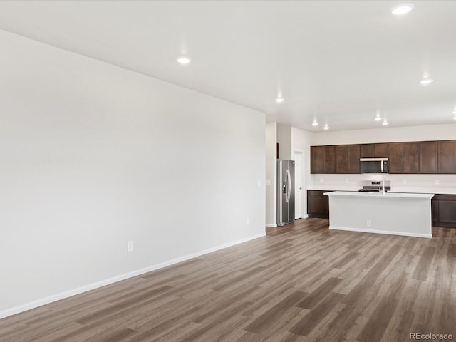 unfurnished living room with light wood-style floors, recessed lighting, and baseboards