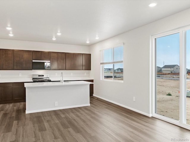 kitchen featuring stainless steel appliances, dark wood-style floors, a sink, recessed lighting, and dark brown cabinets
