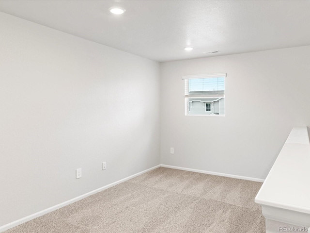 empty room featuring carpet floors, recessed lighting, and baseboards