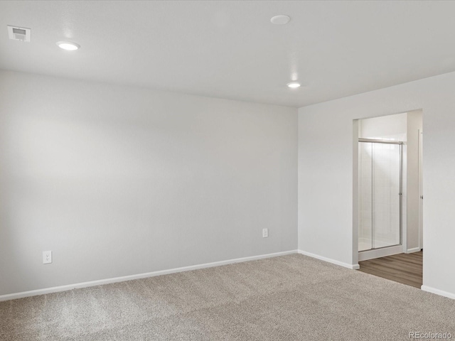 carpeted empty room featuring recessed lighting and baseboards