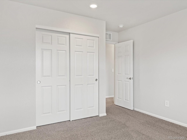 unfurnished bedroom with carpet, baseboards, a closet, and recessed lighting