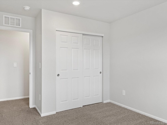 unfurnished bedroom featuring carpet floors, a closet, baseboards, and recessed lighting