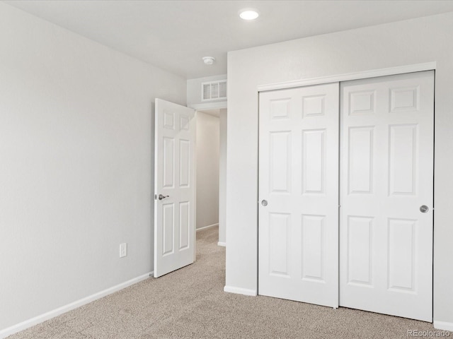 unfurnished bedroom featuring carpet floors, baseboards, a closet, and recessed lighting