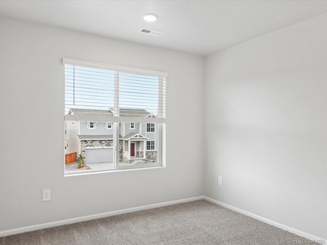 carpeted empty room featuring baseboards