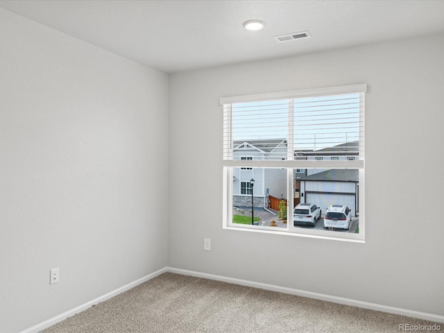 carpeted empty room with baseboards