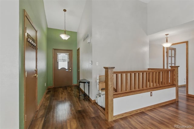 foyer with a high ceiling, wood finished floors, and baseboards