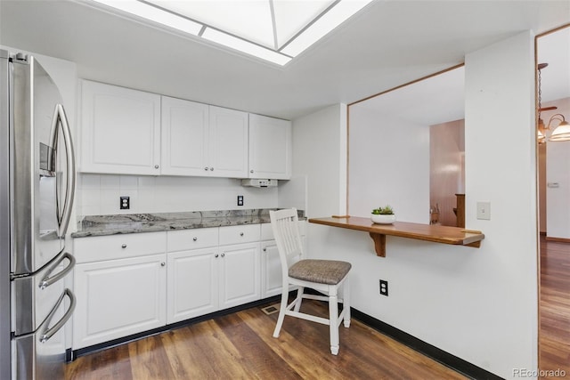 kitchen featuring stainless steel fridge with ice dispenser, dark wood-type flooring, light stone counters, and white cabinets