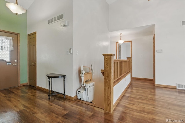 entrance foyer with a towering ceiling, wood finished floors, and baseboards