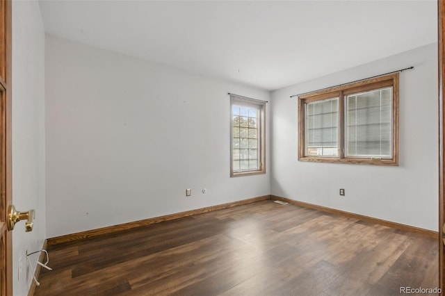 spare room featuring wood finished floors and baseboards