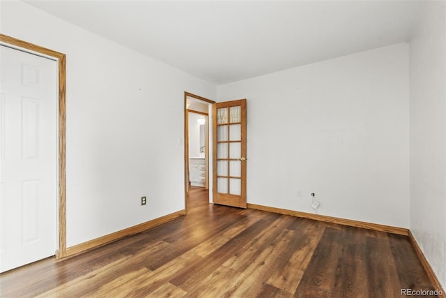 spare room with wood finished floors and baseboards