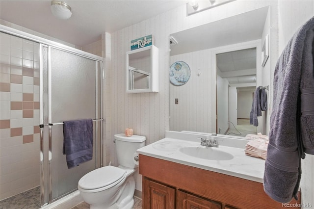 bathroom with toilet, a shower stall, and vanity