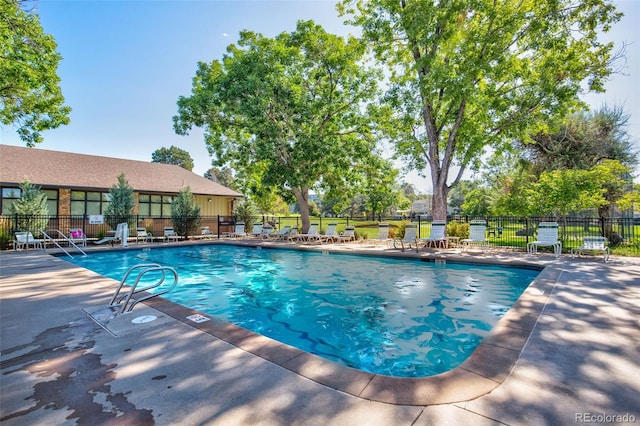community pool featuring fence and a patio area