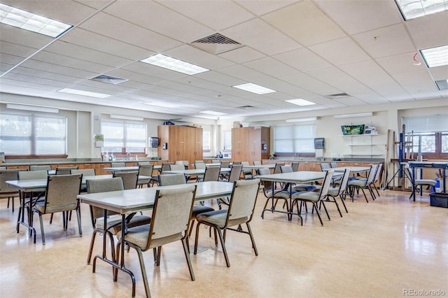 dining area with healthy amount of natural light and a paneled ceiling
