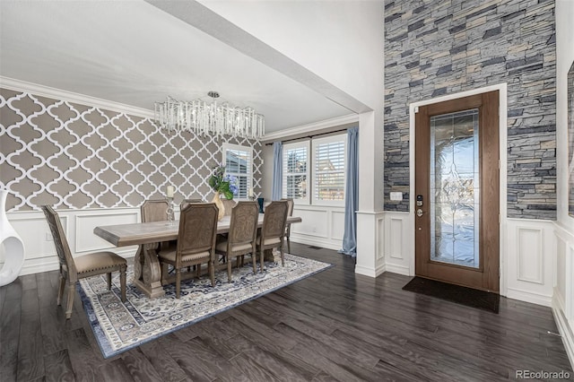 dining space featuring dark hardwood / wood-style flooring, ornamental molding, and a notable chandelier