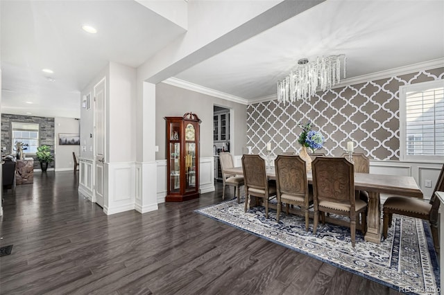 dining space featuring dark wood-type flooring, crown molding, and an inviting chandelier