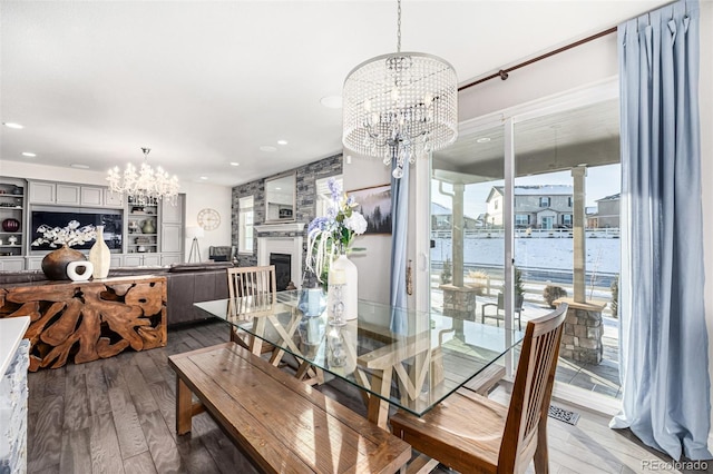 dining space featuring a fireplace, a chandelier, and hardwood / wood-style floors