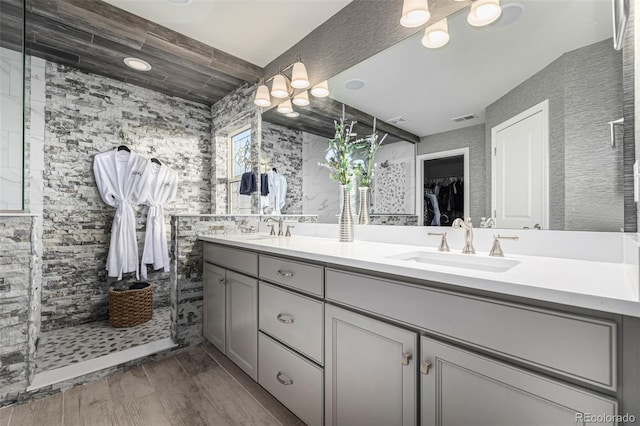 bathroom featuring vanity, tile walls, and tiled shower