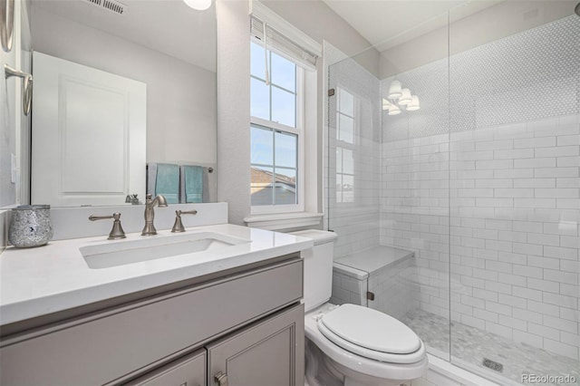 bathroom featuring a chandelier, toilet, vanity, and an enclosed shower