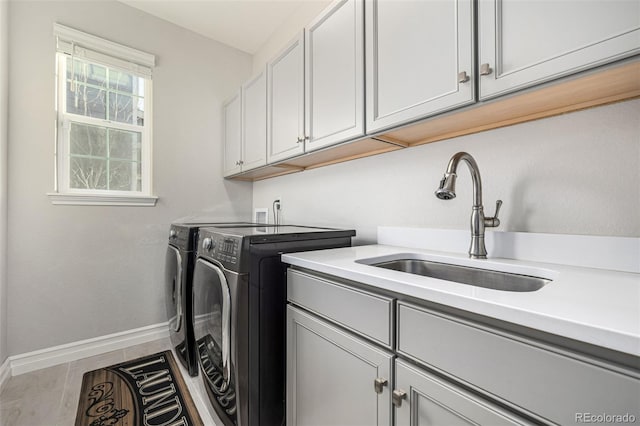 washroom featuring sink, independent washer and dryer, and cabinets