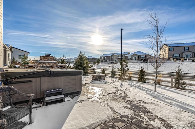 snow covered patio with an outdoor fire pit and a hot tub