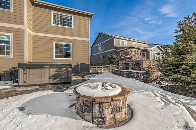 snow covered patio with a hot tub and a fire pit