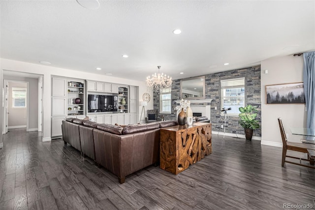 living room featuring dark hardwood / wood-style floors, a fireplace, and an inviting chandelier