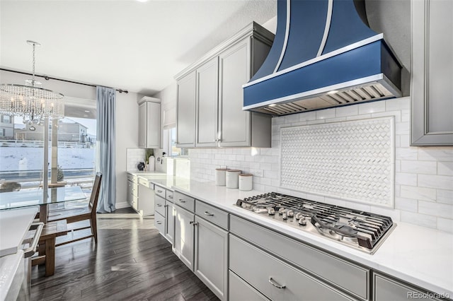 kitchen with dark hardwood / wood-style flooring, gray cabinets, stainless steel gas cooktop, and wall chimney range hood