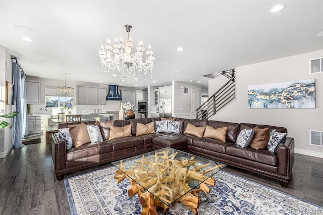 living room with dark hardwood / wood-style floors and an inviting chandelier