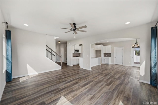 1711 Lazear St, Loveland, CO 80538 - unfurnished living room featuring dark wood-style flooring, arched walkways, ceiling fan, recessed lighting, and baseboards