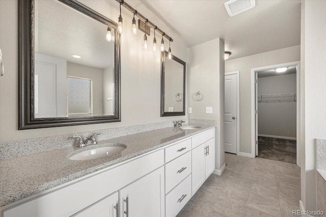 1711 Lazear St, Loveland, CO 80538 - bathroom featuring double vanity, baseboards, and a walk in closet