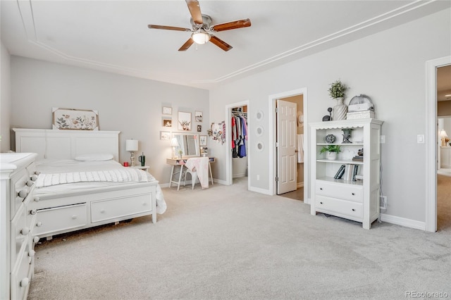 bedroom featuring light carpet, a spacious closet, a closet, and ceiling fan