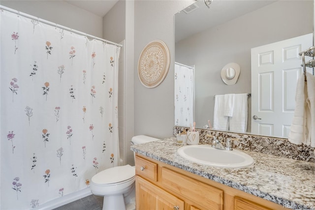 bathroom featuring vanity, tile patterned flooring, and toilet