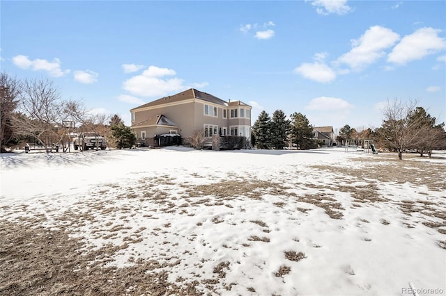 view of snow covered back of property