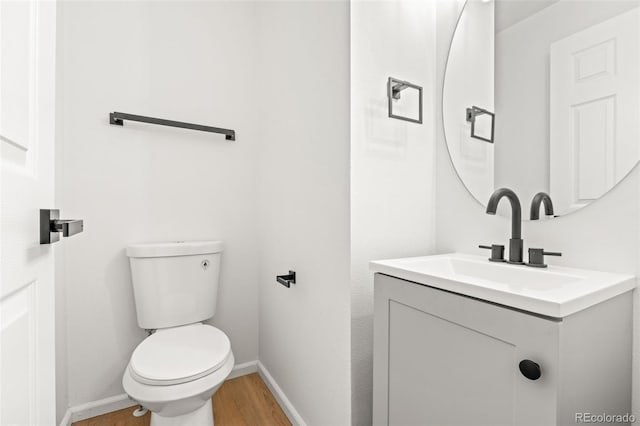 bathroom featuring vanity, hardwood / wood-style floors, and toilet